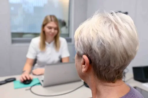 Ženska z diskretnim slušnim aparatom uživa v pogovoru